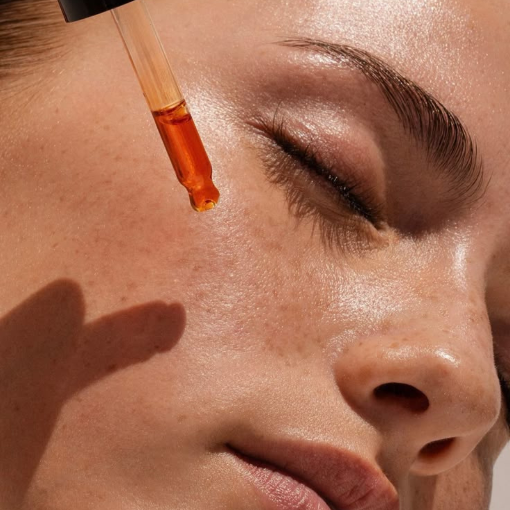 Application de sérum visage Dado Cosmetics sur peau lumineuse, rituel de soin naturel aux huiles précieuses africaines