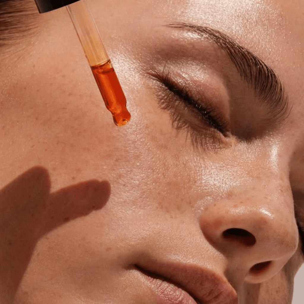 Application de sérum visage Dado Cosmetics sur peau lumineuse, rituel de soin naturel aux huiles précieuses africaines